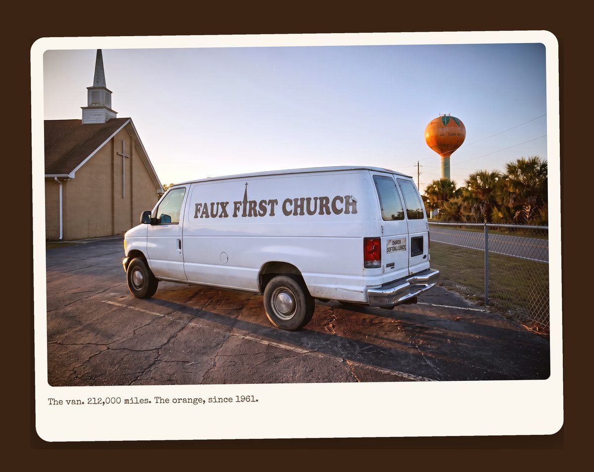 White 1994 Ford E-350 church van beside a water tower painted like an orange