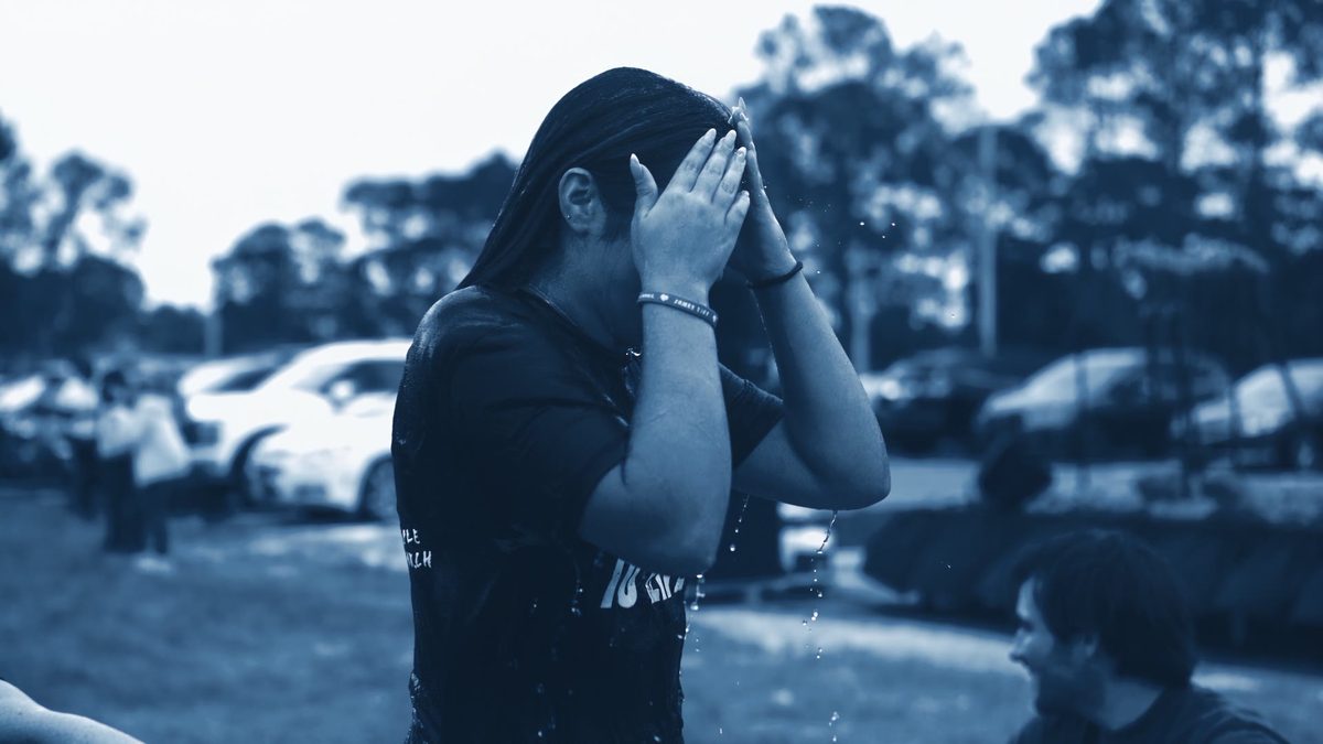 Baptism still, duotone, hands to face