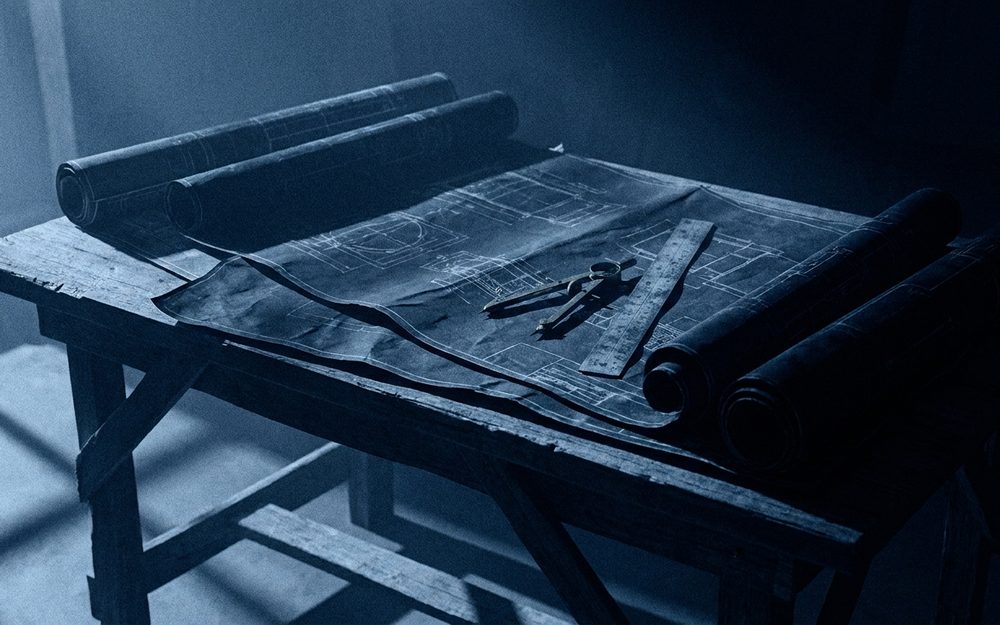 Rolled blueprints on a drafting table