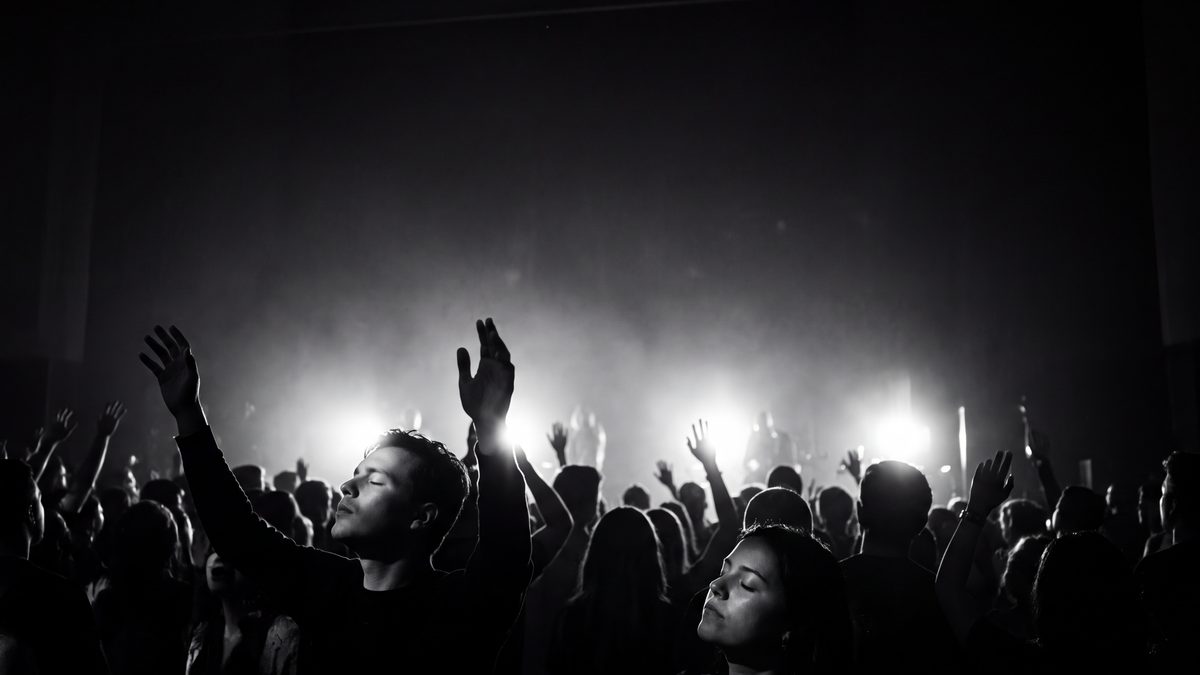 Worship crowd with hands raised, black and white